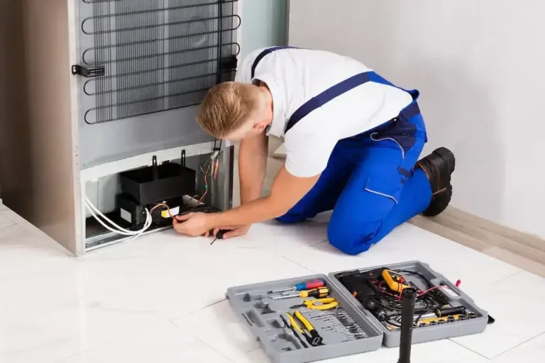Technician diagnosing common Samsung refrigerator problems near the compressor and rear components