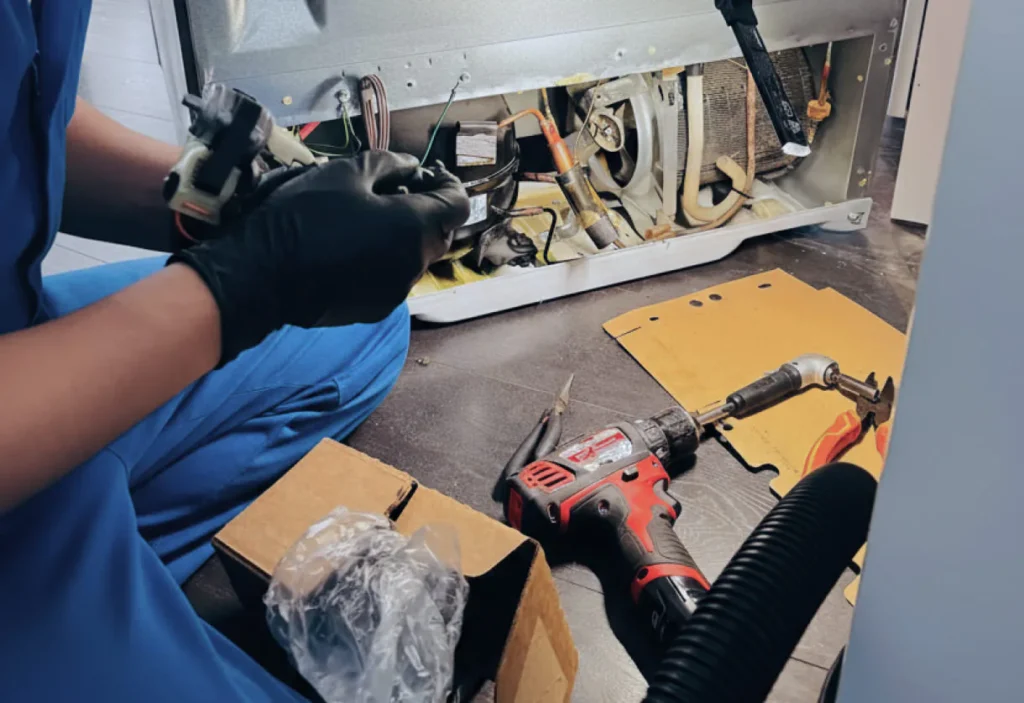 Technician servicing internal components of a Sub-Zero refrigerator during routine maintenance